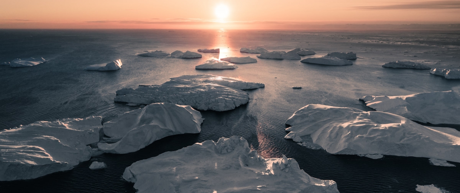 The sun perfectly aligned with the ice bergs that evening. Photo by Ben Simon Rehn - Visit Greenland