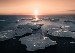 The sun perfectly aligned with the ice bergs that evening. Photo by Ben Simon Rehn - Visit Greenland