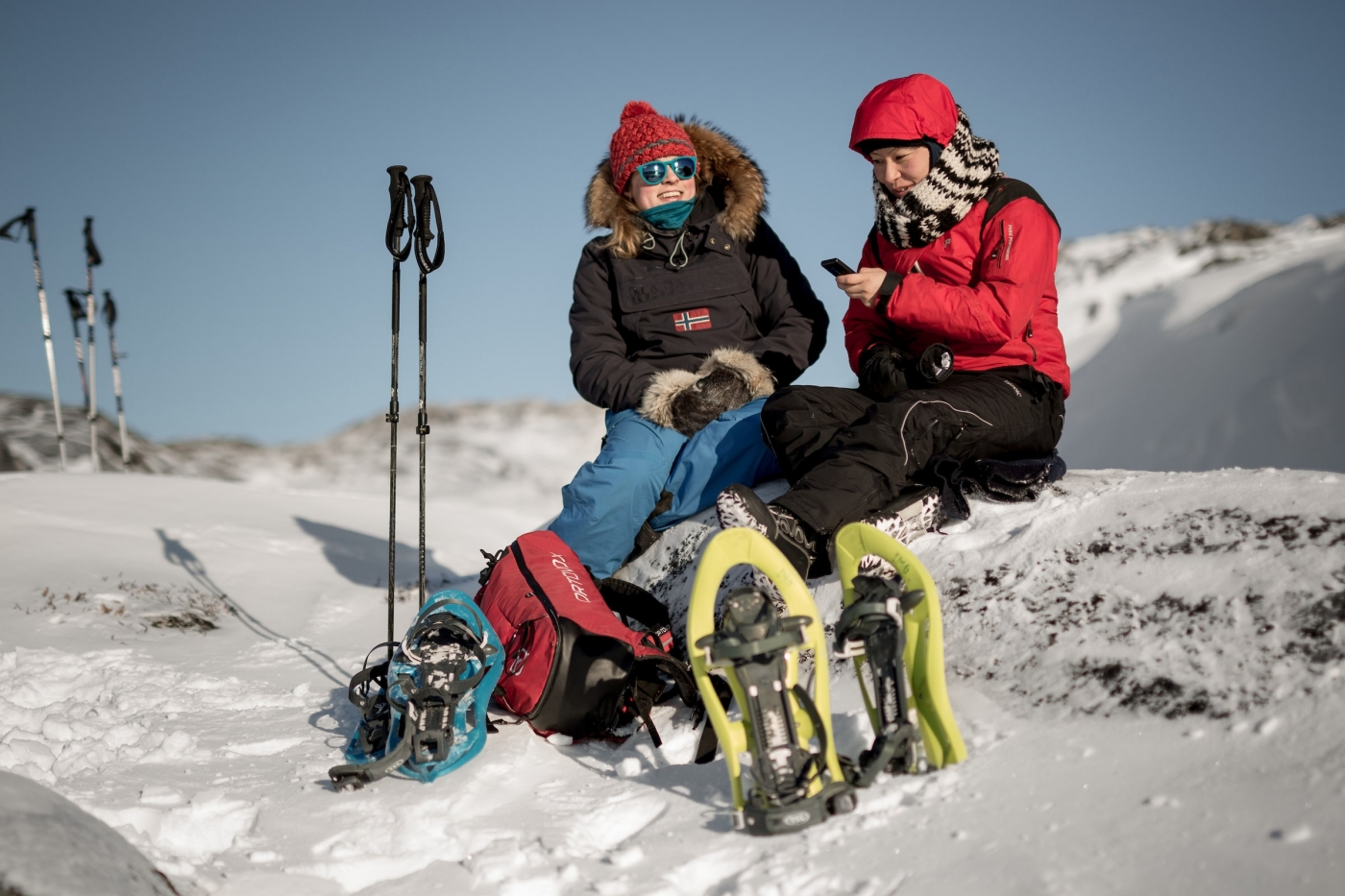 Two snowshoers taking a break to update their lives on social media near Iluissat in Greenland. Photo by Mads Pihl - Visit Greenland