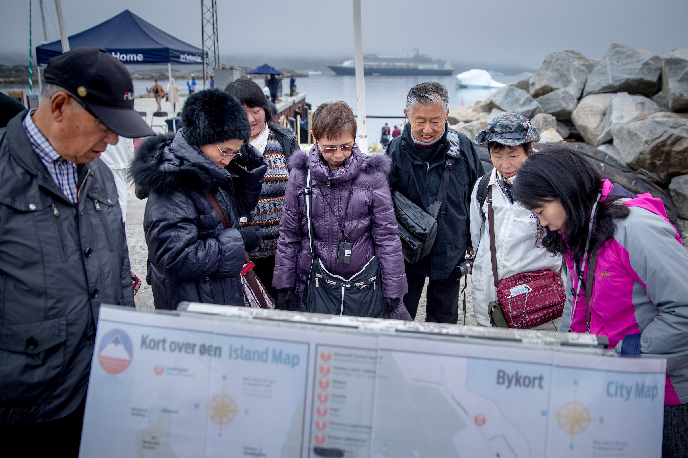 Cruise guests in Nanortalik in South Greenland studying a map of town. Photo by Photo by Mads Pihl - Visit Greenland