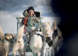 A Chinese traveler looking back at a following dog sled near Ilulissat in Greenland. Photo by Mads Pihl