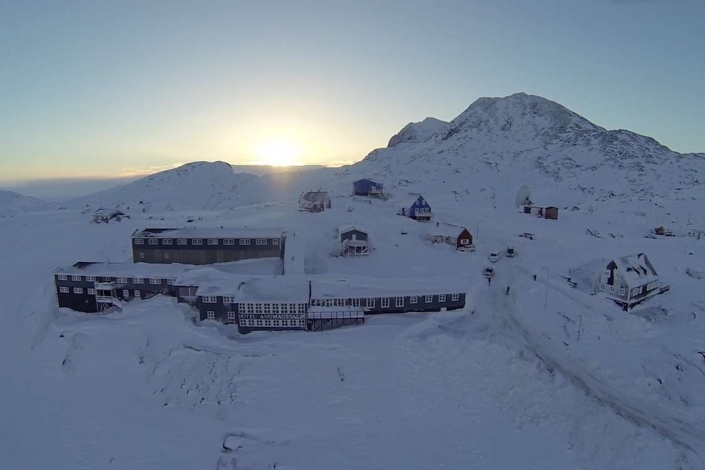 Aerial view of the hotel with sunrise in background in Winter. Photo by Hotel Angmagssalik