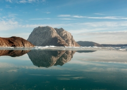 Mountains being reflected perfectly on clear water in the Nuuk fjord in Greenland. Photo by Rebecca Gustafsson - Visit Greenland