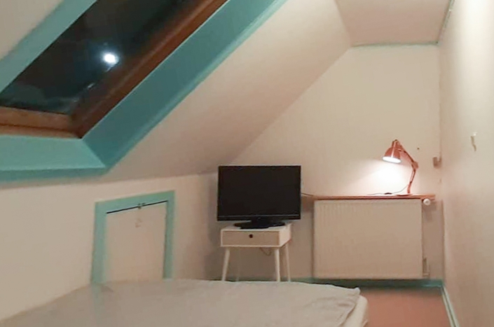 Bedroom under the roof with tv. Photo by Mikami Hostel