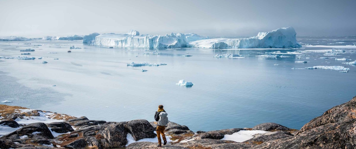 Person admiring the beautiful view of icefjord in Ilulissat. Photo by Alex Aavu - Visit Greenland