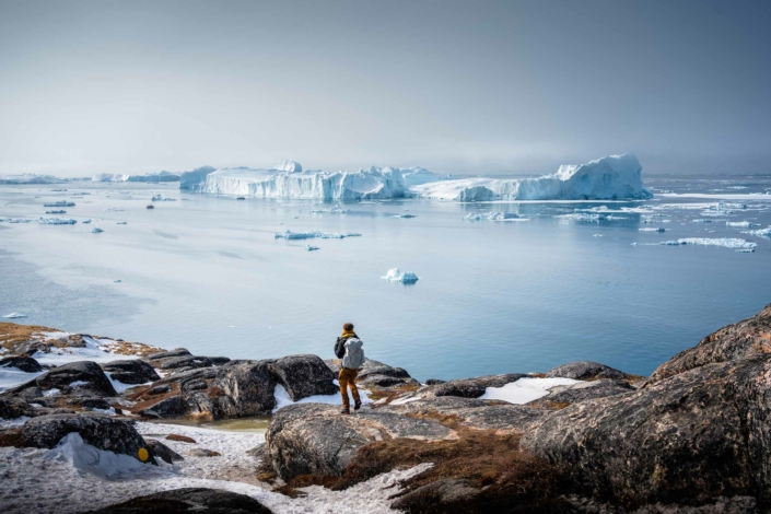 Person admiring the beautiful view of icefjord in Ilulissat. Photo by Alex Aavu - Visit Greenland