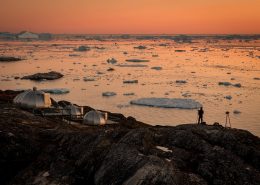A photographer in the sunset near Hotel Arctic in Ilulissat in Greenland. By Mads Pihl