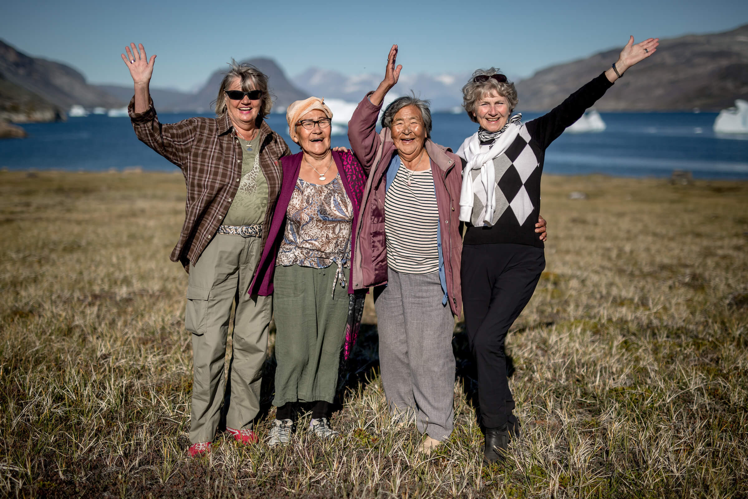 Four women waving hello in Narsaq in South Greenland. Photo by Mads Pihl