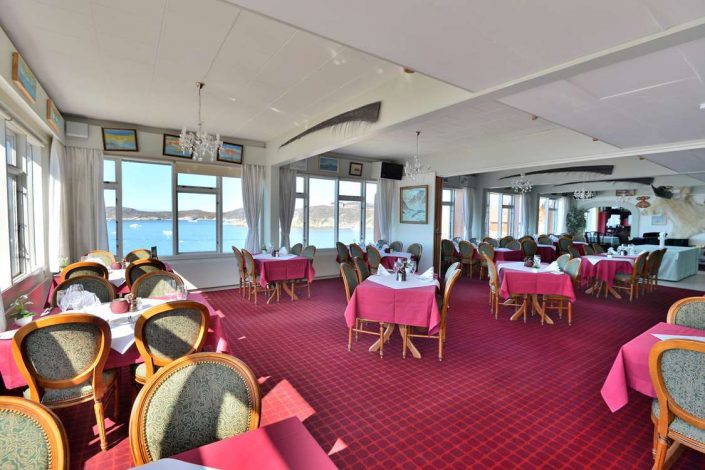 Inside view of the restaurant with a view of Ilulissat Icefjord in the background. Photo by Restaurant Hvide Falk