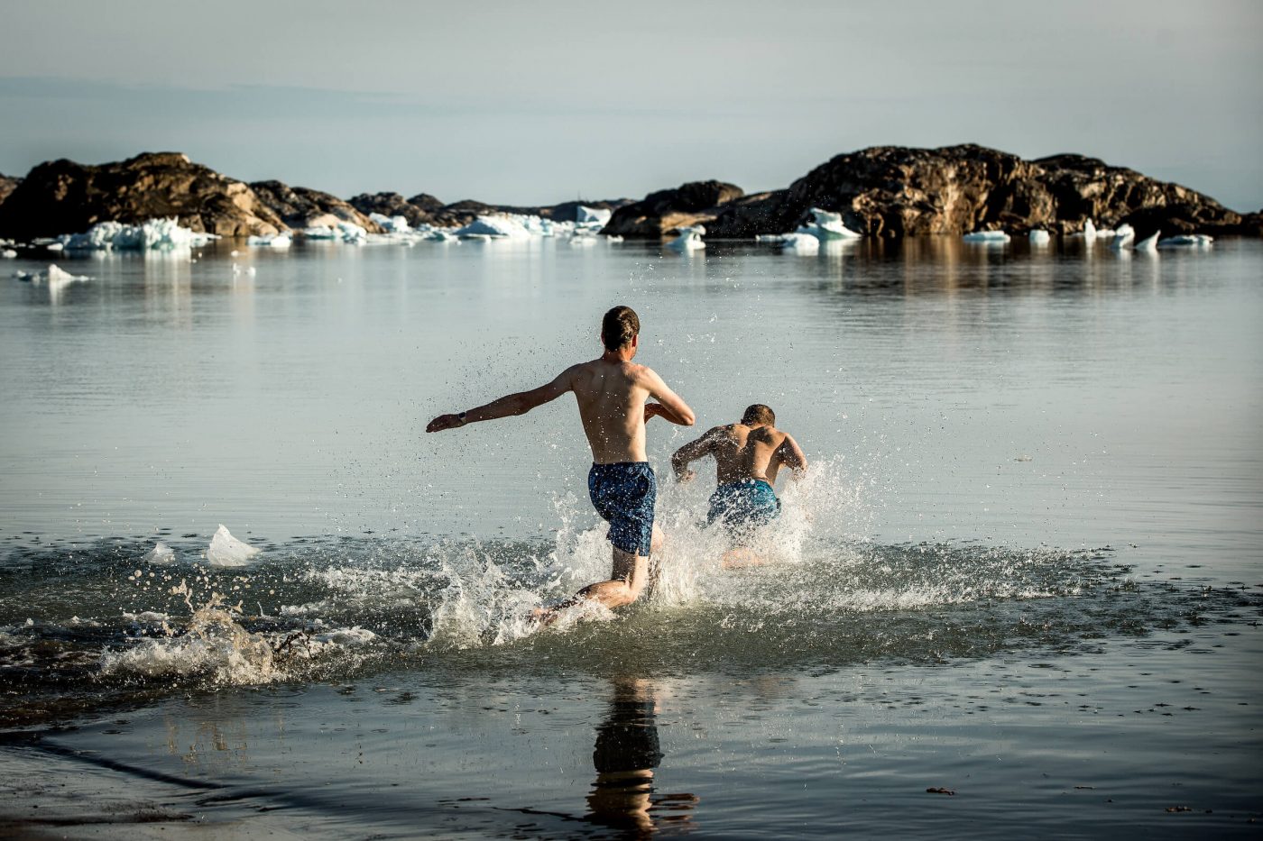 Two hikers in East Greenland going for an icy swim in Sermilik fjord. Photo by Mads Pihl