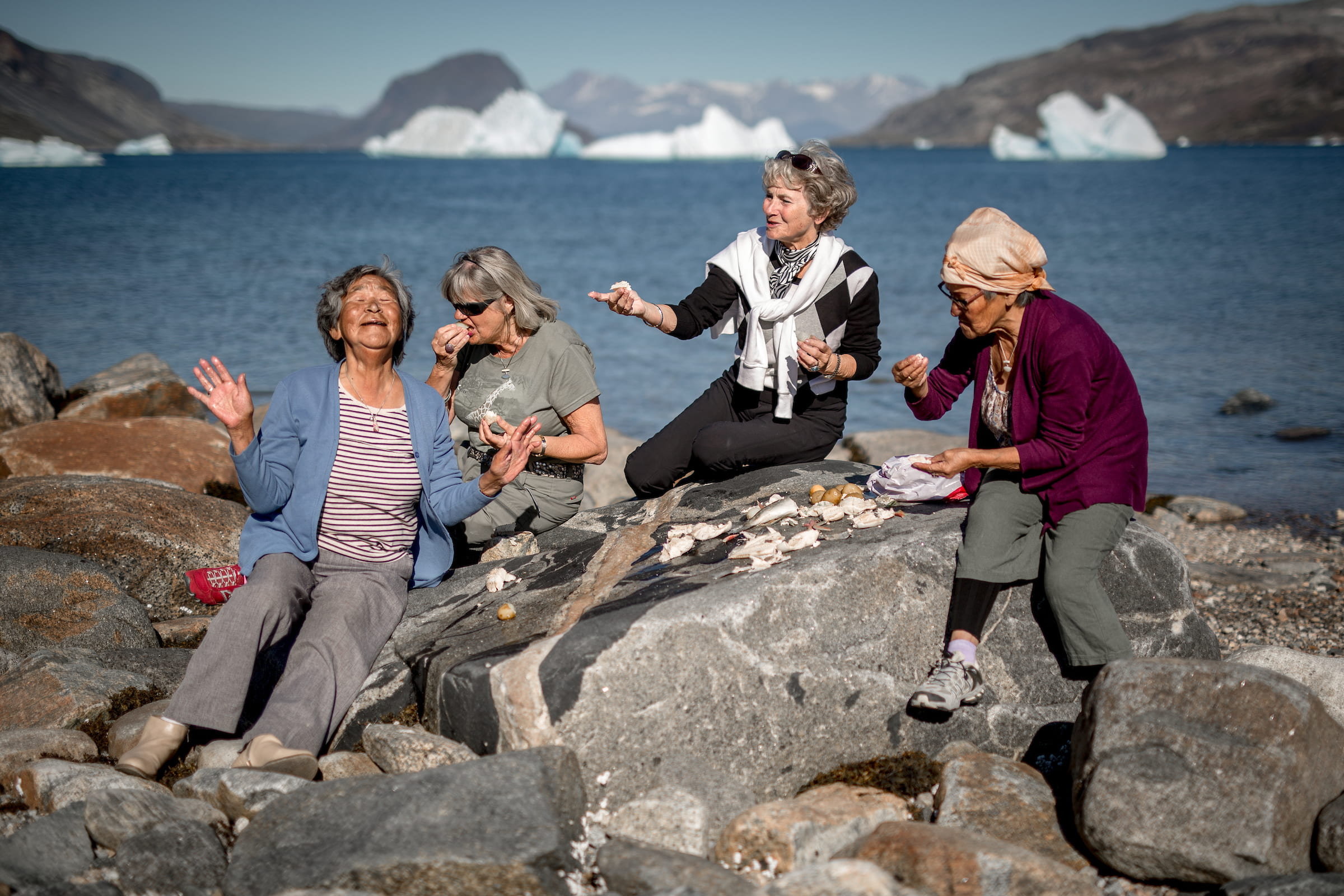 Four women sharing fun stories at an outdoor meal in Narsaq in South Greenland. By Mads Pihl