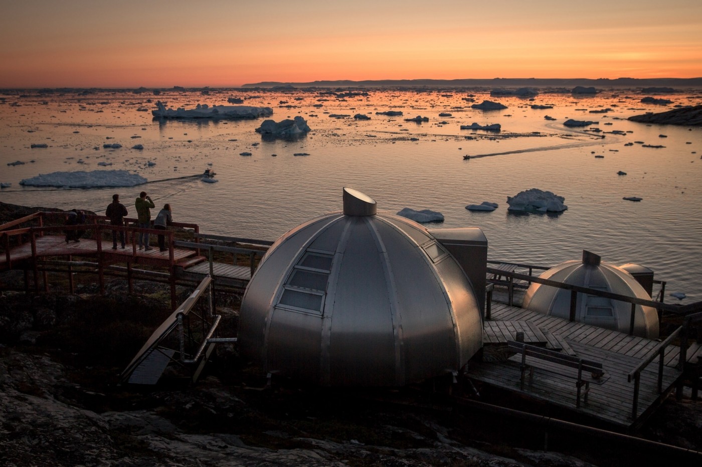 Photographers in the sunset near the Hotel Arctic igloos in Ilulissat in Greenland. Photo by Mads Pihl - Visit Greenland
