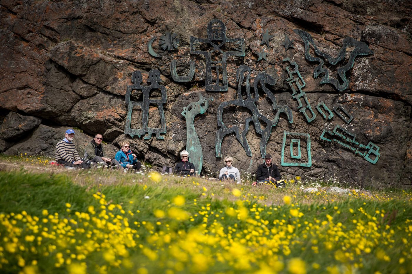 A group of travelers having lunch in front of the Sven Havsteen Mikkelsen artwork in Qassiarsuk. By Mads Pihl