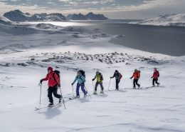 A group of skiers climbing a mountain near Kulusuk on a ski touring trip in East Greenland