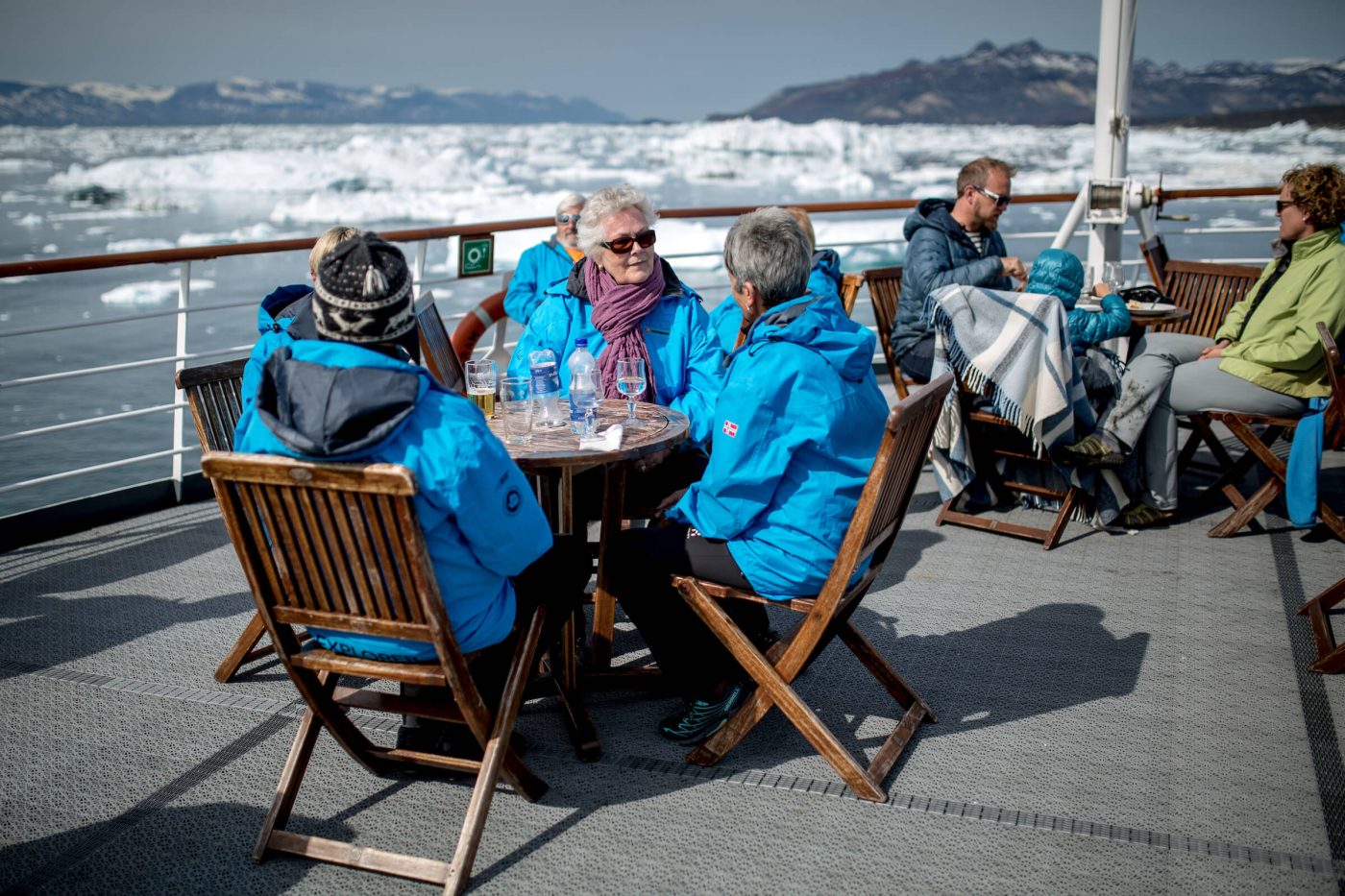 Cruise guests having lunch on the upper deck of MS Fram in the Disko Bay in Greenland. Photo by Mads Pihl
