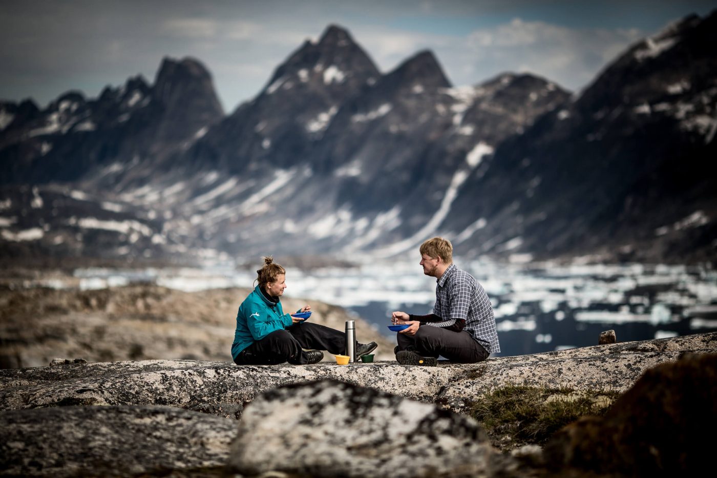 Two hikers having breakfast at a campsite near Qernertivartivit in East Greenland. By Mads Pihl